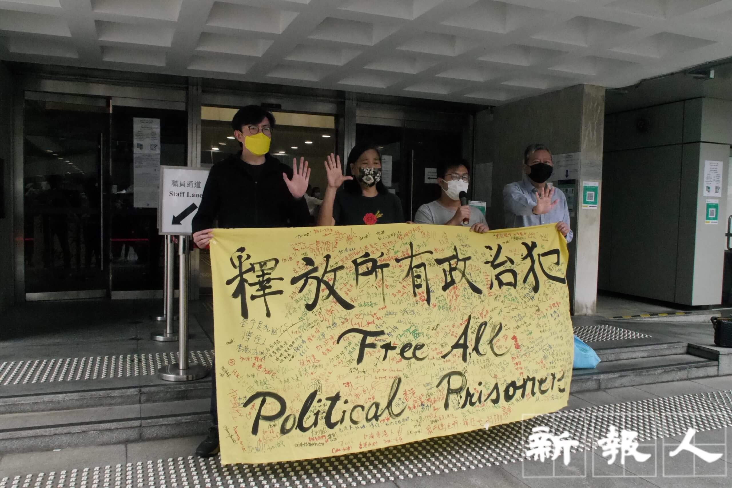 社民連秘書長吳文遠、副秘書長陳寶瑩、社民連主席黃浩銘、支聯會主席李卓人(左至右)開庭前於高等法院門外拉起橫額,聲援被告。