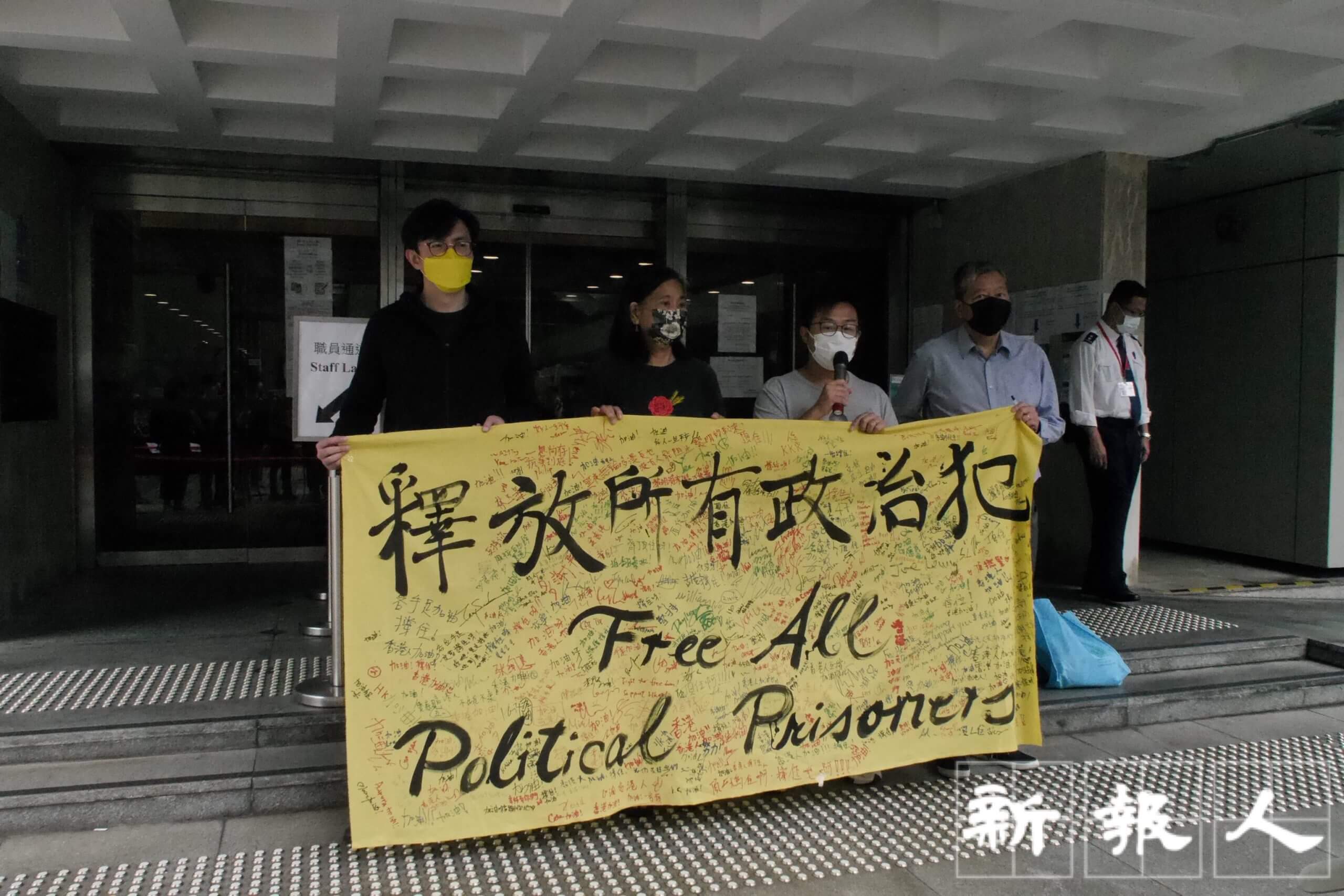 社民連秘書長吳文遠、副秘書長陳寶瑩、社民連主席黃浩銘、支聯會主席李卓人(左至右)開庭前於高等法院門外拉起橫額,聲援被告。